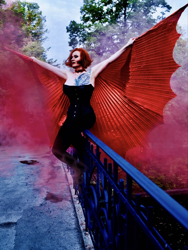 Ein Foto von einer Frau mit roten Flügel.