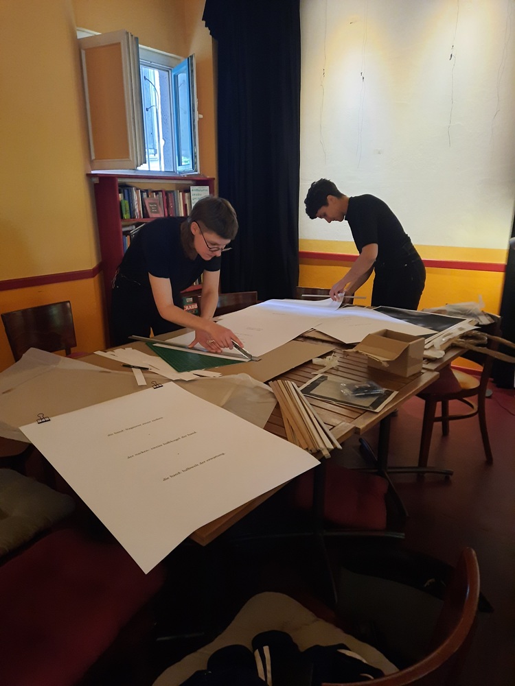 Zwei junge Frauen arbeiten am Tisch und vorbereiten ein Ausstellung 