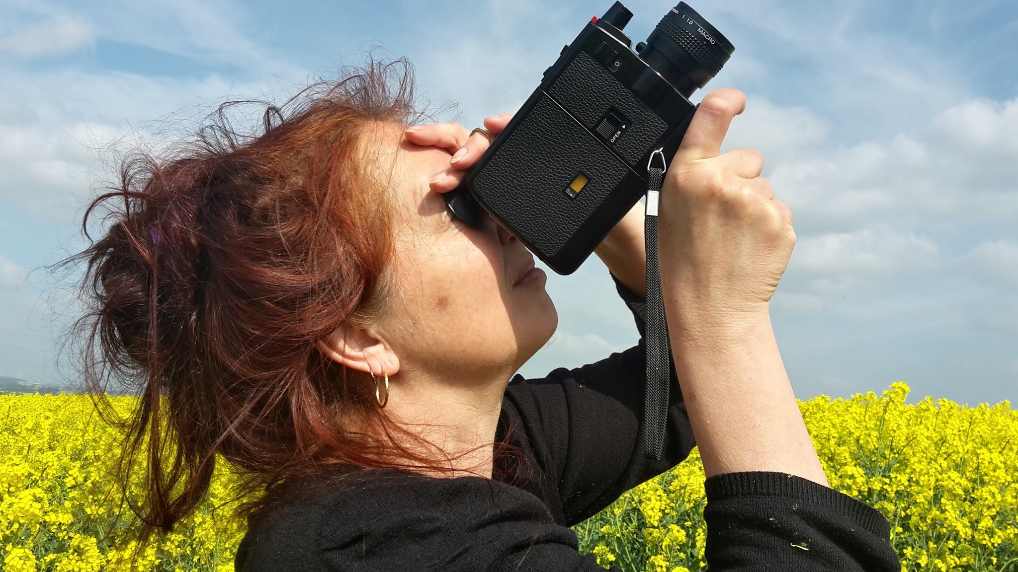 Dagie Brundert mit Kamera vor einem Rapsfeld