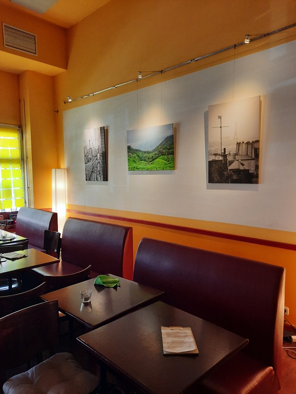Ein Foto von hängenden Fotos auf einer Wand im BEGINE -Café